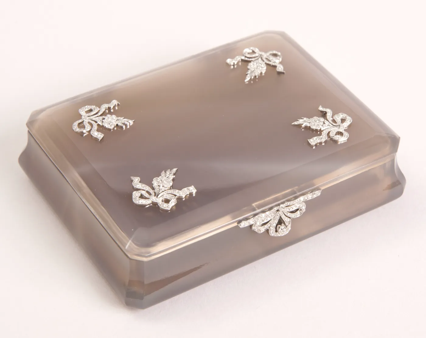 A translucent keepsake box with ribbon-bow clasps